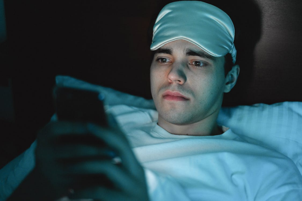 Person lying awake at night using a phone, reflecting late-night search trends.