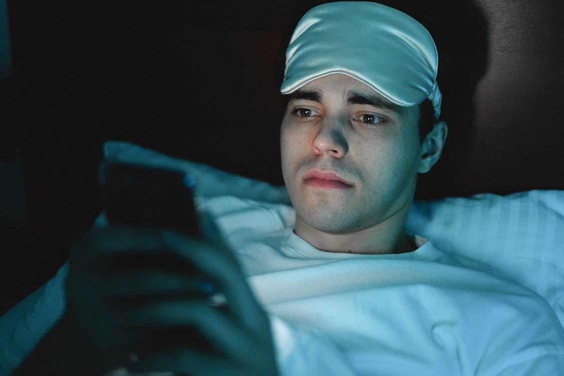 Person lying awake at night using a phone, reflecting late-night search trends.