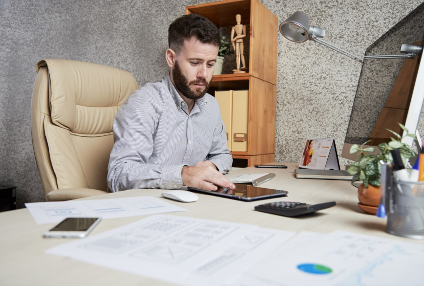 Person reviewing finances at a desk reflecting financial literacy search trends.