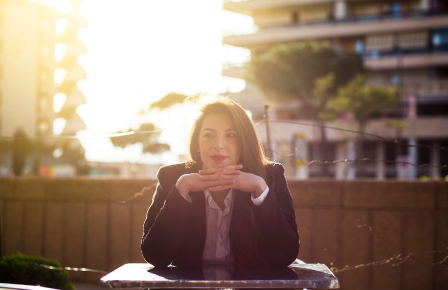 Woman sitting thoughtfully outdoors reflecting changing definitions of success.