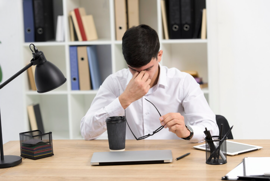 Office worker showing burnout at a desk, illustrating why quiet quitting keeps trending.